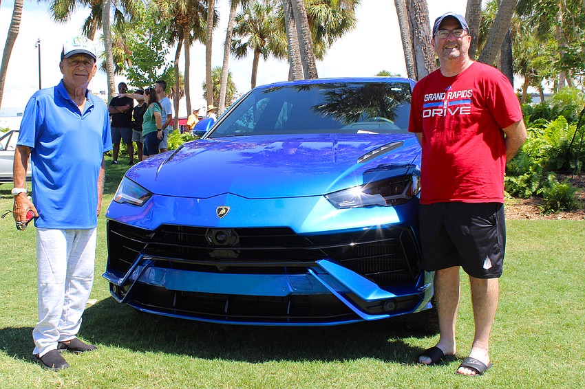 Angelo Zeno, 87, and his son-in-law, Jim Carr, pose for a photo by the Lamborghini with their favorite paint job at Exotic Cars on the Circle.